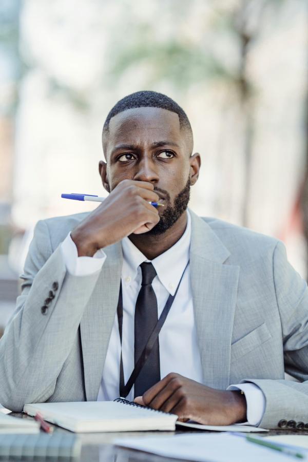 Man in a suit sitting looking thoughtful
