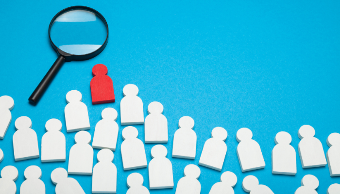 many white figures with one red figure standing out