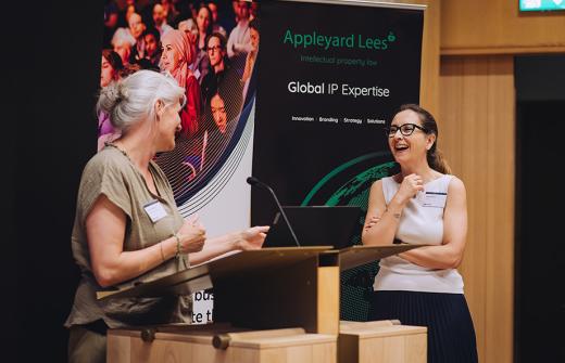 Two presenters at the 2025 Milner Pitch Day at a podium