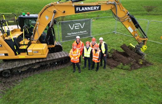 people standing next to a digger 
