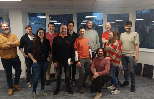 A group of 12 people standing and smiling.