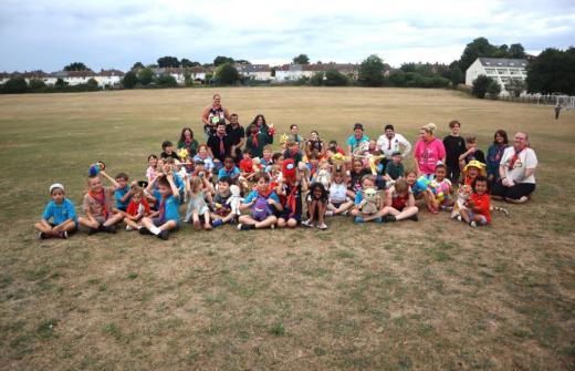 2nd Newmarket Scout Group sat together in a field looking at the camera