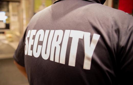 A close up rear view of a security guard's shirt with the word security across his back