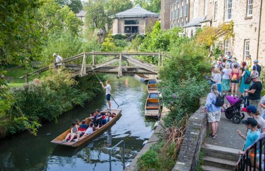 Punts on the river with people around 