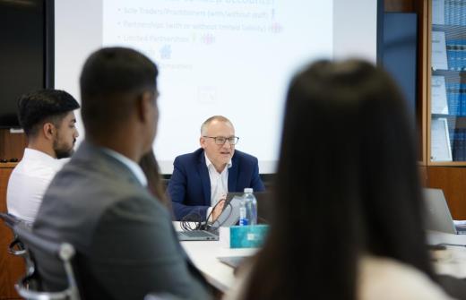 Price Bailey trainees sit together in a meeting