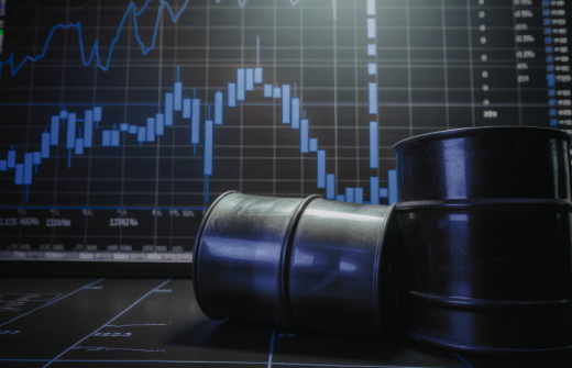 A graph showing rising inflation and two oil drums in front. 
