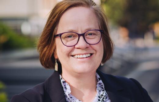 Headshot of a person wearing glasses outside