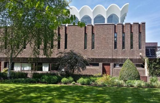 Brick building with a white roof that resembles the sails on a boat, FItzwilliam College, Cambridge Dining Hall