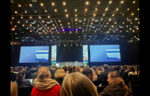 Huge audience watching Simon give a presentation in the far distance on a stage