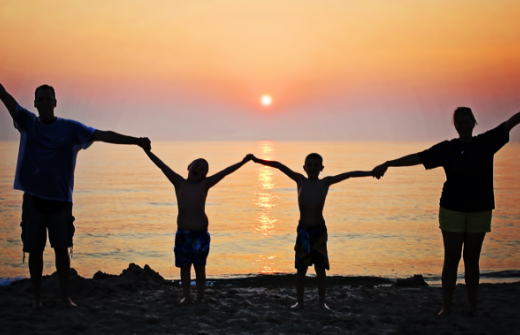 a family of 4 enjoying the sunset 