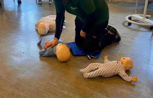 Administering first aid to a doll