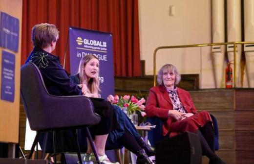 Sarah Hawkes, Laura Bates and Raewyn Connell sat on a stage at an event, Global 50/50 in Dialogue. 