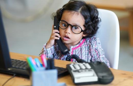 Young girl at a desk on a work phone call