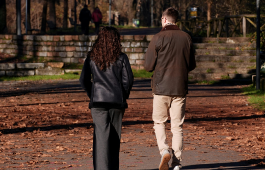 A man and a woman walking through a park