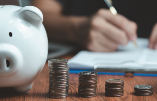 a white piggy bank with a row of coins stacked next to it