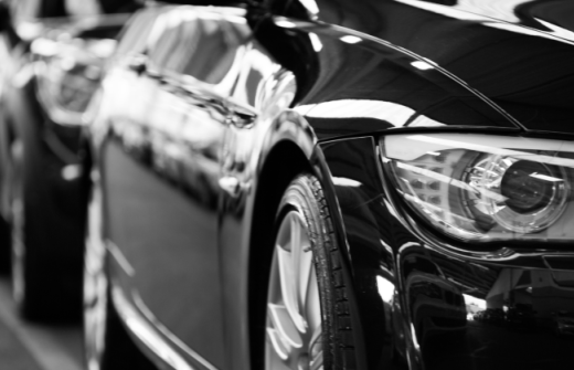 A BLACK AND WHITE PHOTO OF A ROW OF BLACK CARS