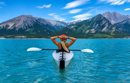 A woman on a kayak overlooking mountains