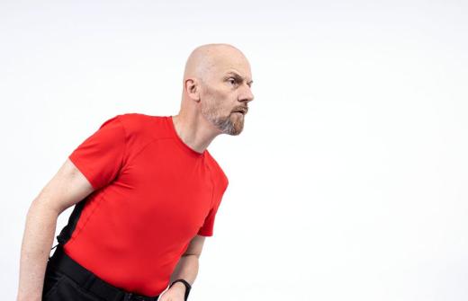 A bald man in a red t-shirt.
