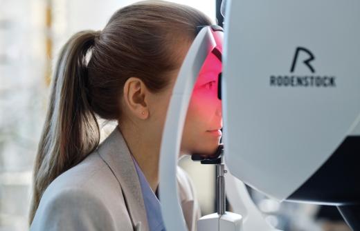 Female patient using Rodenstock eye scanner during eye exam