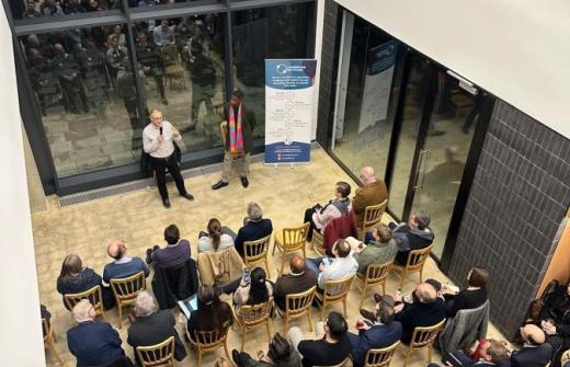 2 speakers talking to a seated crowd