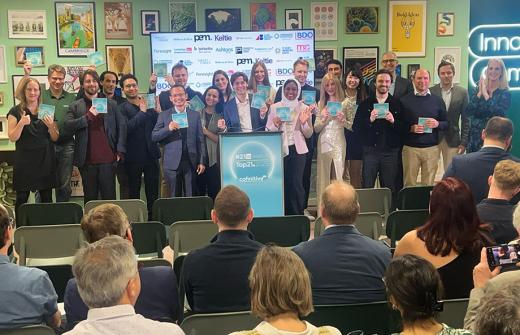 A group of people gathered around a podium holding award certificates