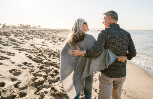 A man and woman walking on the beach