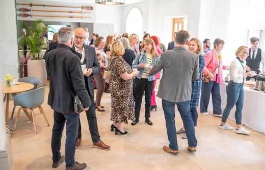 A group of people standing up & networking at King's College Cambridge