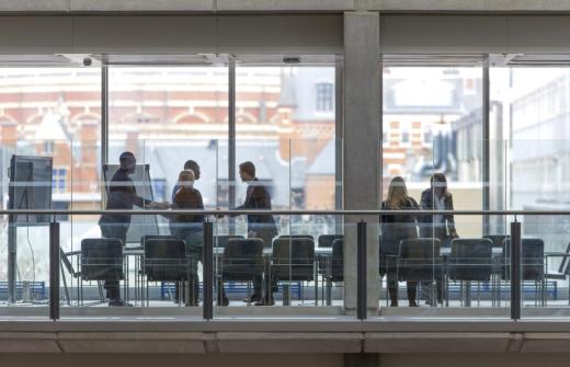 People shake hands in a meeting room