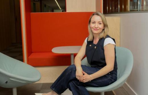 Photo of Kate Waters sitting on a chair in an office environment 