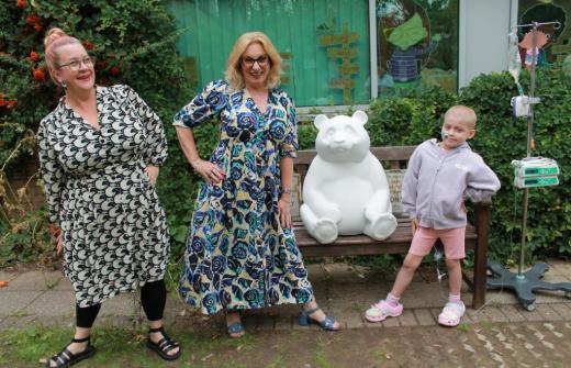 Pilgrim Pathways headteacher Nadine, with Sarah Bush, Head of Residential, at Cheffins, with the panda cub - and eight-year-old school pupil, Ava