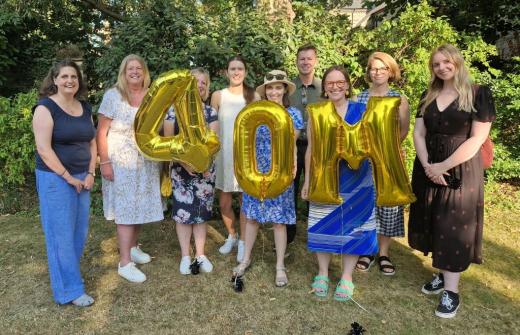 Staff team celebrating the milestone, holding up '40m' balloons