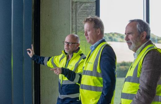 Left to right: Jason Longhurst, UK Head of Sustainable Investment and Partnerships at Prologis, Paul Bristow, Mayor of Cambridgeshire and Peterborough, and Andrew Blevins, SVP Life Sciences at Prologis overlook the development site from inside the nearly completed new GSK R&D centre on Cambridge Biomedical Campus. 