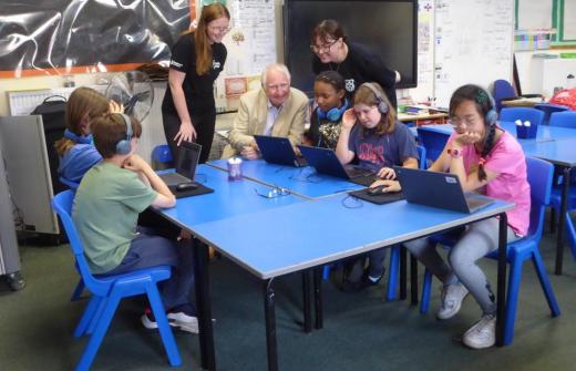 a man talking to children in a school setting 
