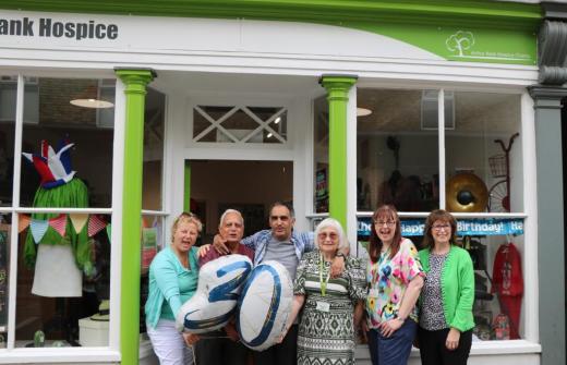 Males and females outside a shop with a balloon