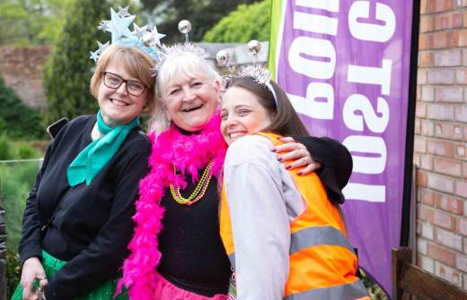 3 females dressed in bright colours smiling 