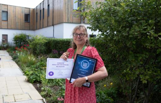 Female outside holding certificates