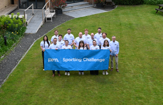 A group of people behind a banner in a garden