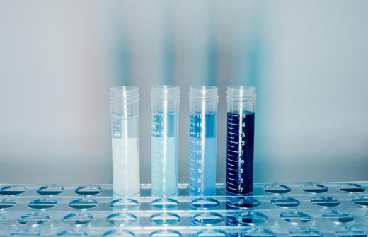 Four test tubes containing liquids, each of a different shade of blue. 