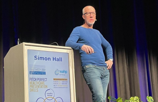 Simon giving a presentation in a mid blue top