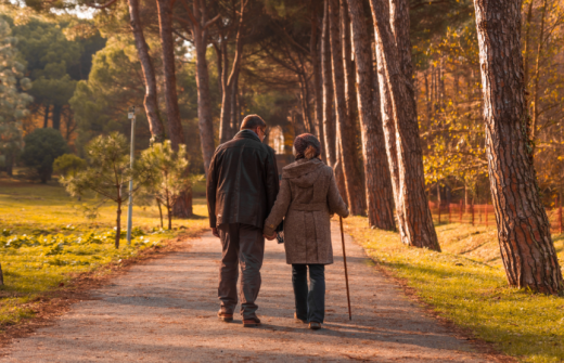 an older couple taking a walk through the park