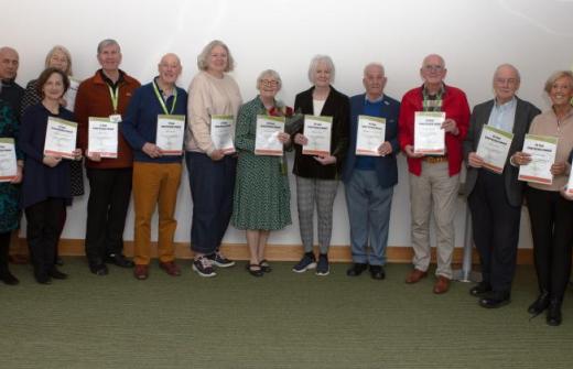 A group of adults holding certificates 