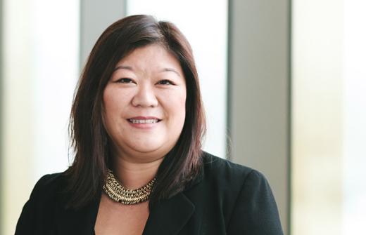 Lady with dark hair in a black suit jacket with a necklace