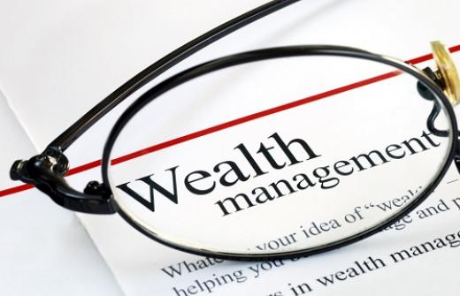 A printed page with the title' Wealth management' visible under a pair of spectacles