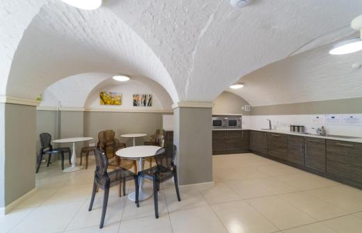 A bright spacious kitchen area with a table and chairs in the foreground