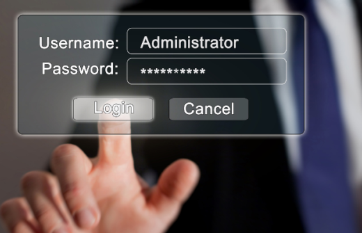A hand with an outstretched finger pressing a button that says login on a computer screen, with the Username field completed as Administrator and the Password field starred out. 