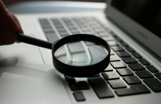 a laptop with a magnifying glass over the keys