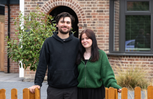 man and women standing in front of a house