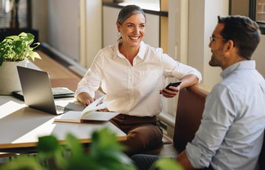 Two colleagues sit next to each other in an office environments