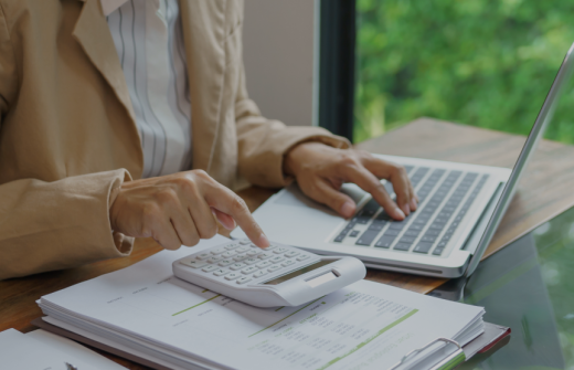 A woman doing her taxex online using a calculator