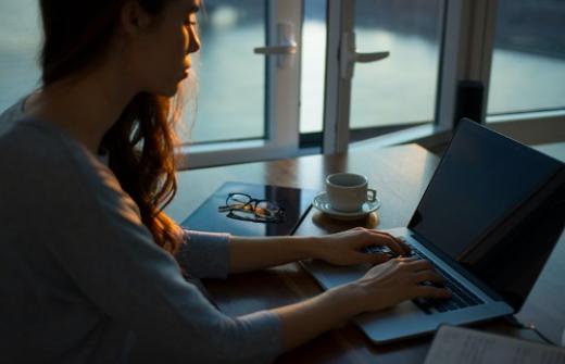 Woman sitting at laptop writing